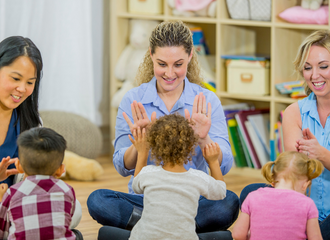 Three ladies playing with small children